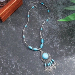 Detail of bohemian heart turquoise pendant necklace with silver leaf charms