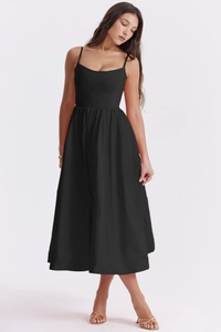 Detailed view of backless black slip dress featuring thin straps and waist-slimming silhouette