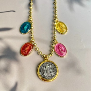 Detail of gold beaded chain necklace with Virgin Mary and religious saint medallions