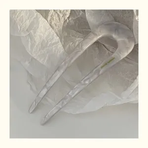 Detailed close-up of marble pattern acetate U-shaped hair fork with France Handmade logo