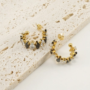 Primer plano de pendientes en C de oro de 18K con circonitas marquise blancas y negras