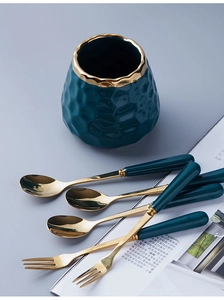 Detailed view of luxury gold stainless steel cutlery with green ceramic handles and jar