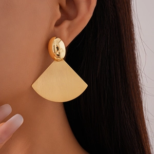 Detail of gold geometric earring with polished oval stud and brushed fan-shaped pendant