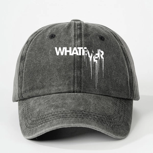 Close-up of white Whatever ink print on charcoal grey washed denim baseball cap