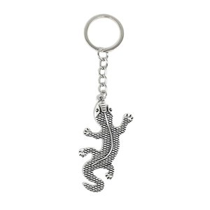 Silver metal lizard keychain with textured hollow pattern on a white background