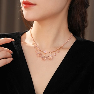 Detail of elegant gold necklace featuring pink zircon flower and teardrop pendants