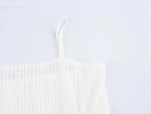 Close-up of white mesh fabric detail and adjustable thin spaghetti strap of the dress