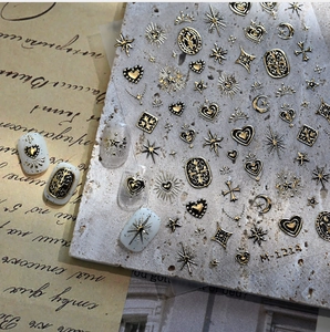 Detailed 3D embossed nail stickers featuring vintage gold and black heart and star motifs