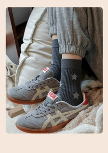 Detail of star-embroidered cotton crew socks paired with grey suede sneakers and gum soles