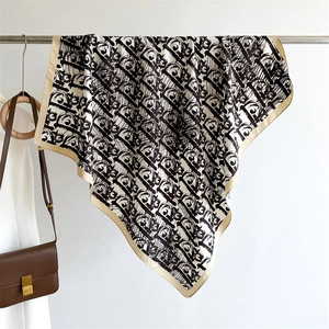 Detail of luxury twill silk square scarf featuring black and white monogram patterns