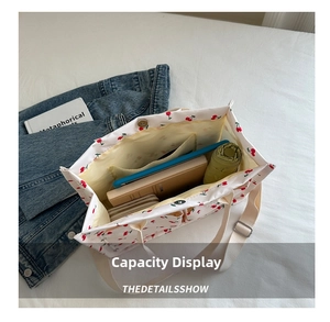 Top view showing cherry print tote bag capacity with tablet, umbrella and notebook