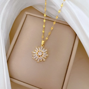 Detail showing a gold snowflake necklace with micro-pave crystals on a soft fabric