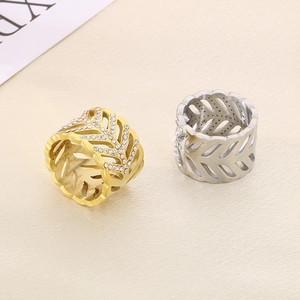 Detailed view of gold and silver hollow leaf rings with sparkling white diamonds