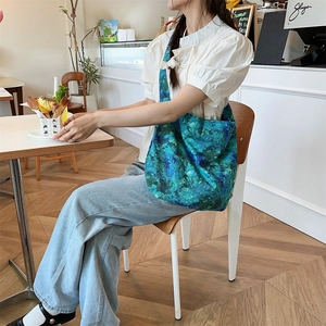 Detail of a large turquoise leopard print canvas tote bag in a casual cafe setting