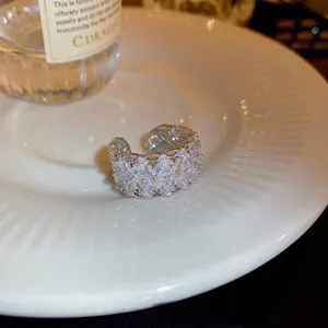 Lace hollow zircon flower open ring in silver finish on a white ceramic tray