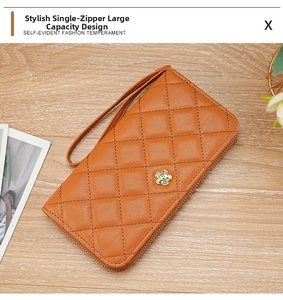 Detail of caramel quilted wristlet wallet with golden camellia floral buckle closure