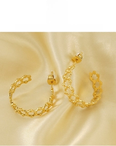 Macro di orecchini placcati oro 18K con trama a nido d'ape su sfondo di seta dorata