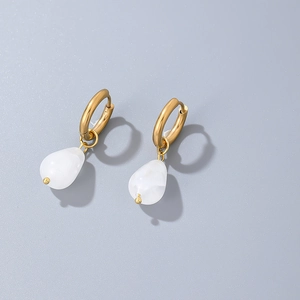 Close-up of golden hoop earrings featuring elegant white teardrop stone pendants