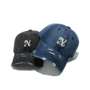 Distressed denim baseball cap with vintage N letter patch in black and dark blue tones
