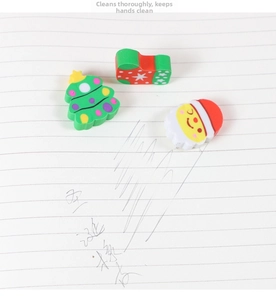Detail view of Christmas tree and Santa erasers set on lined paper background