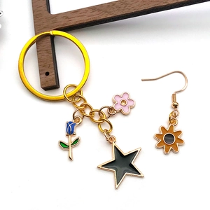 Detail of gold enamel alloy charms including pink flower, blue tulip, and star pendant