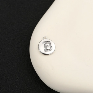 Primer plano del colgante letra B de plata con circonitas para joyería hecha a mano