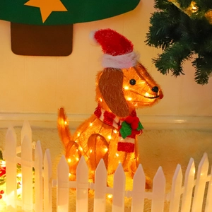 Detail of dachshund dog light with red Christmas hat and striped scarf decoration