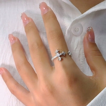 Close-up of silver knot ring with sparkling crystals worn on a finger