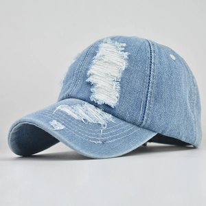 Close-up of light blue distressed denim baseball cap showing ripped texture and twill fabric