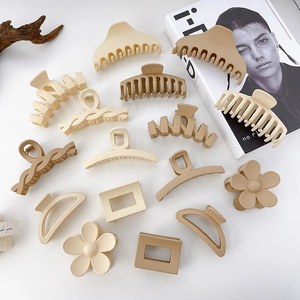 Collection of matte resin hair claws in beige and cream colors with varied shapes