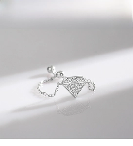 Macro shot of silver S925 sterling silver chain ring with geometric diamond pendant