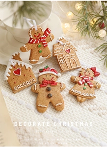 Close-up of resin gingerbread man and house ornaments with warm festive lighting