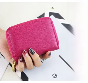 Close-up of rose red litchi texture card wallet with gold metal zipper detail