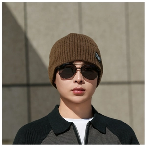 Close-up of dark brown ribbed knit beanie featuring a branded square patch for winter warmth