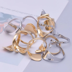 Detailed view of stacked wavy minimalist gold and silver adjustable steel rings