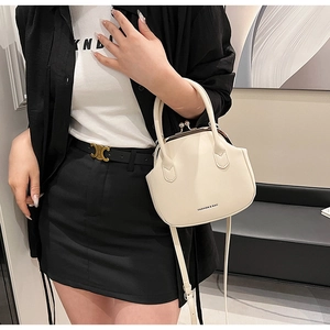 Detail of beige retro leather handbag with kiss-lock closure and gold-toned hardware
