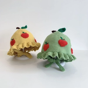 Cute apple-themed knitted baby hats in yellow and green with soft ruffled brims