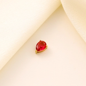 Detail of a red pear-cut zircon charm with a gold-tone claw setting for jewelry DIY