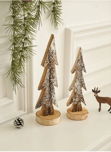 Close-up of wooden Christmas tree ornaments with natural bark and white snowy finish