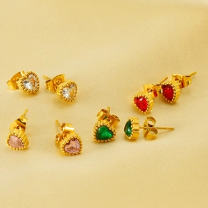 Macro shot of 18K gold plated heart stud earrings with multi-colored zircons on silk fabric