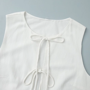 Detailed view of white sleeveless vest with tie-up bow closure in cotton linen fabric