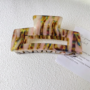 Detail of large marble texture acetate hair claw clip with square cutout design