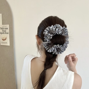 Elegant grey satin oversized scrunchie for hair styling on a female model