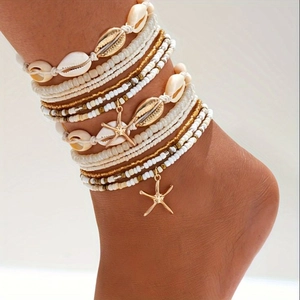 Detail of layered seashell anklet with gold starfish charm and beads on woman ankle