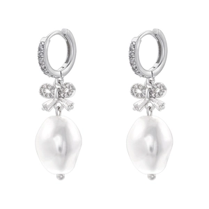Detailed view of silver bow earrings with zircon stones and irregular rice pearls