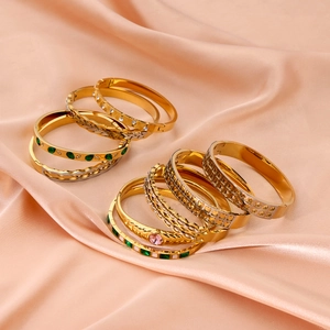 Detailed macro shot of 18k gold-plated stainless steel bangles with colorful gemstones