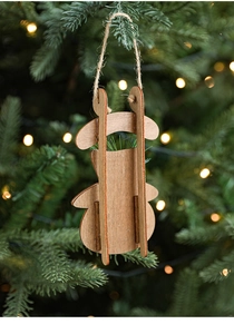 Close-up of a natural wooden Santa pendant hanging on a Christmas tree branch