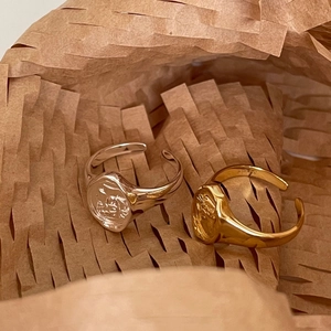 Irregular 925 sterling silver coin rings in gold and silver finishes on textured paper