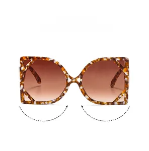Detail of tortoise frame sunglasses with hollow geometric temples and brown lenses