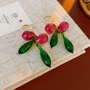 Détail des boucles d'oreilles cerise avec perles en verre translucide rose et vert